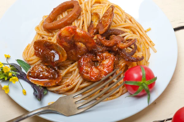 Italiaanse zeevruchten spaghetti pasta op rode tomatensaus — Stockfoto