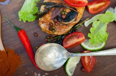 Ahşap kovuk ahşap güvertede tavuk göğsü pişirdi baharatlar ve sebzelerle.