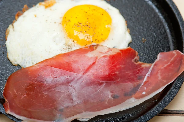 Egg sunny side up with italian speck ham — Stock Photo, Image