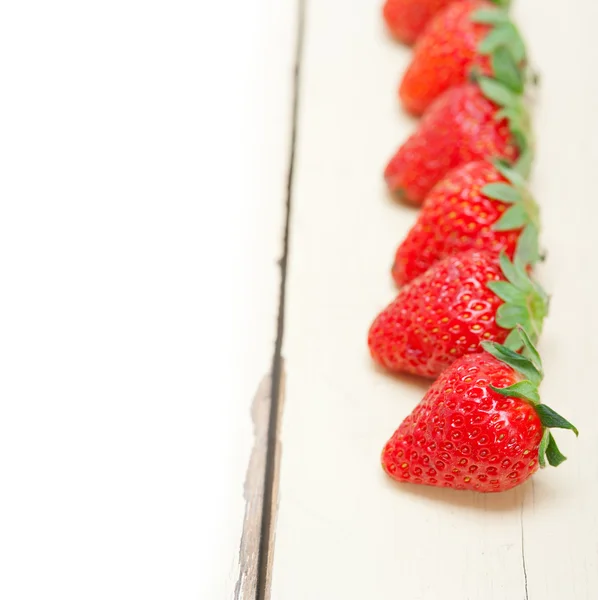Φρέσκα βιολογικά φράουλα πάνω από λευκό ξύλο — Φωτογραφία Αρχείου
