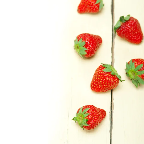 Fresh organic strawberry over white wood — Stock Photo, Image