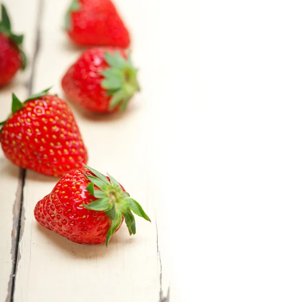 Fresh organic strawberry over white wood — Stock Photo, Image