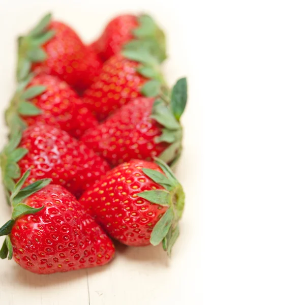 Färska ekologiska jordgubbar över vitt trä — Stockfoto