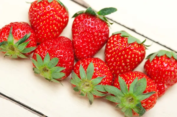 Färska ekologiska jordgubbar över vitt trä — Stockfoto