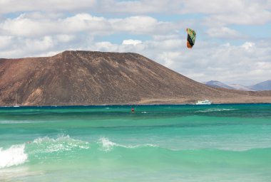 Bilinmeyen kitesurfer Corralejo, Fuerteventura Atlas Okyanusu'nda düz masmavi bir su üzerinde sörf,