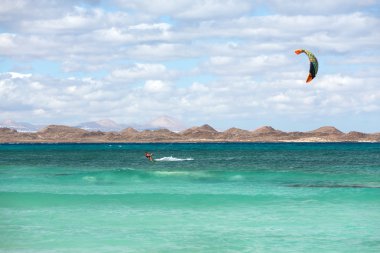  Bilinmeyen kitesurfer Corralejo, Fuerteventura Atlas Okyanusu'nda düz masmavi bir su üzerinde sörf