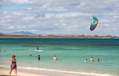 Bilinmeyen kitesurfer Corralejo, Fuerteventura, Kanarya Adaları, İspanya Atlas Okyanusu'nda düz masmavi bir su üzerinde sörf