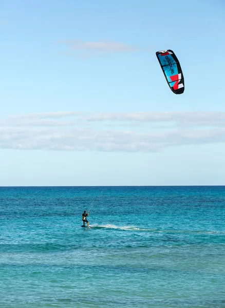 Kitesurfer sconosciuto che fa surf su un'acqua azzurra piatta dell'oceano Atlantico a Corralejo, Fuerteventura, Isole Canarie, Spagna — Foto Stock