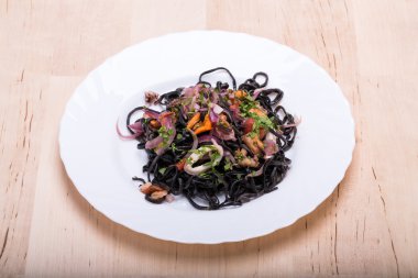 Deniz ürünleri ve sebze ile siyah spagetti