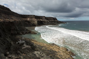Puertito beach de los Molinos Fuerteventura üzerinde bir kayaya üzerine sıçramasına el salla. Kanarya Adaları, İspanya
