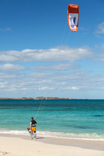 Onbekende kitesurfer surfen op een plat azuurblauwe water van de Atlantische Oceaan in Corralejo, Fuerteventura, Canarische eilanden, Spanje — Stockfoto