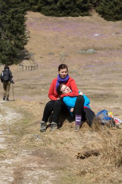 Dağ çayır çiçek açan, Çiğdem çiçeklerle Chocholowska Vadisi, Tatra Dağları, Polonya oturan genç turist