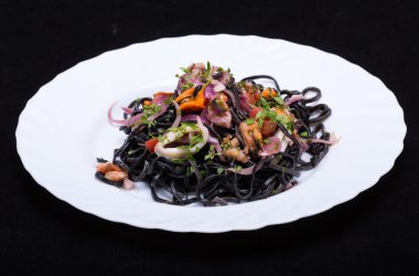Deniz ürünleri ve sebze ile siyah spagetti