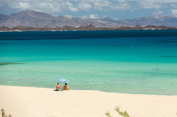 I turisti riposano sulla spiaggia di Corralejo a Fuerteventura, Isole Canarie — Foto Stock