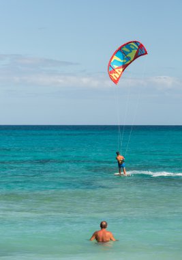 Bilinmeyen kitesurfer Corralejo, Fuerteventura, Kanarya Adaları, İspanya Atlas Okyanusu'nda düz masmavi bir su üzerinde sörf