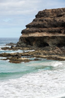 Puertito beach de los Molinos Fuerteventura üzerinde bir kayaya üzerine sıçramasına el salla. Kanarya Adaları, İspanya
