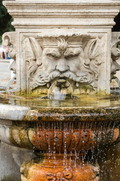 Mramorová fontána ve tvaru hlavy muže v zahradách Villa Borghese, Řím, Itálie. — Stock fotografie