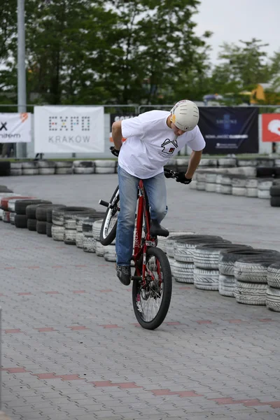 身份不明的年轻男子骑小轮车自行车在克拉科夫的摩托车表演第三版. — 图库照片