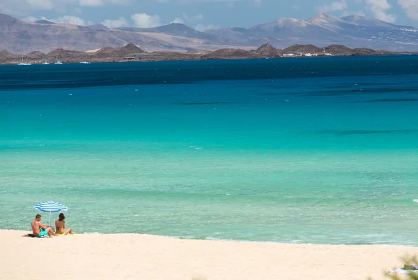 Toeristen rusten op Corralejo strand op Fuerteventura, Canarische eilanden — Stockfoto