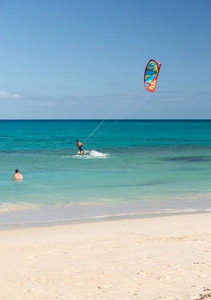 Onbekende kitesurfer surfen op een plat azuurblauwe water van de Atlantische Oceaan in Corralejo, Fuerteventura, Canarische eilanden, Spanje Stockafbeelding