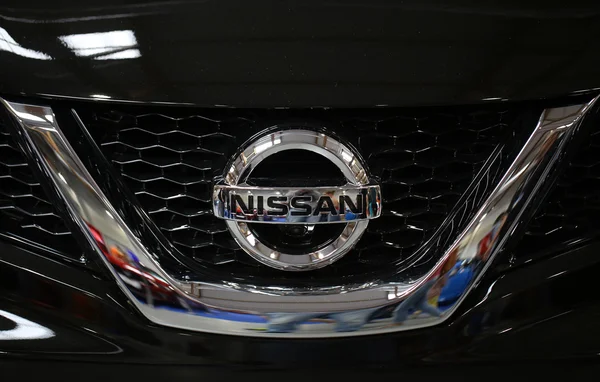 : Primer plano del logotipo metálico de Nissan en el coche de Nissan — Foto de Stock