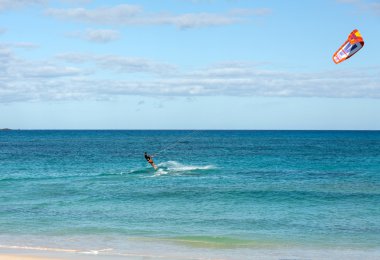 Bilinmeyen kitesurfer Corralejo, Fuerteventura, Kanarya Adaları, İspanya Atlas Okyanusu'nda düz masmavi bir su üzerinde sörf