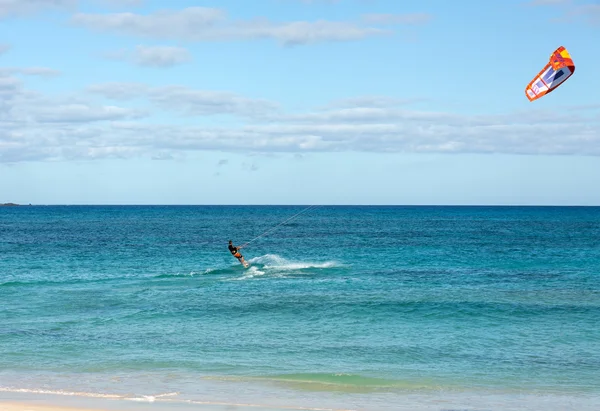 Kitesurfer sconosciuto che fa surf su un'acqua azzurra piatta dell'oceano Atlantico a Corralejo, Fuerteventura, Isole Canarie, Spagna — Foto Stock