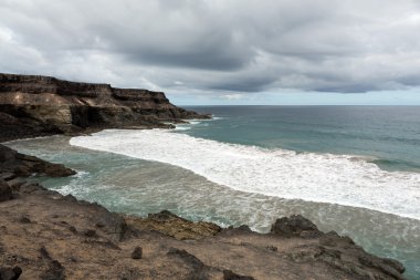 Puertito beach de los Molinos Fuerteventura üzerinde bir kayaya üzerine sıçramasına el salla. Kanarya Adaları, İspanya