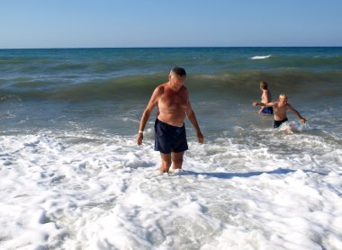 Üst düzey bir adam dalga deniz Chania plajında duruyor. Crete Adası,