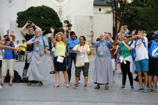 Les pèlerins des Journées Mondiales de la Jeunesse chantent et dansent sur la place principale de Cracovie. Pologne — Photo