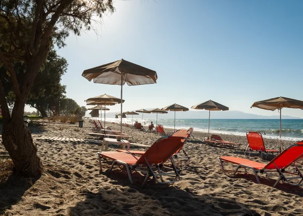 Solstolar och skugga parasoll på en strand på Kreta — Stockfoto