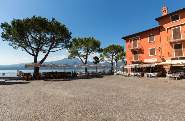 Gardasjön med strandpromenad och restaurang i Torri del Benaco, — Stockfoto