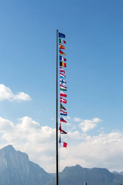De nationale vlag en de vlag van de Europese Unie vliegen in de wind voor een blauwe hemel. — Stockfoto