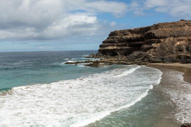 Puertito beach de los Molinos Fuerteventura üzerinde bir kayaya üzerine sıçramasına el salla. Kanarya Adaları, İspanya