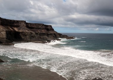 Puertito beach de los Molinos Fuerteventura üzerinde bir kayaya üzerine sıçramasına el salla. Kanarya Adaları, İspanya