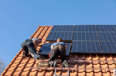 Ochojno, Polonya - 8 Nisan 2020: İşçiler Ochojno 'da bir evin çatısına güneş enerjisi panelleri kuruyorlar. Polonya
