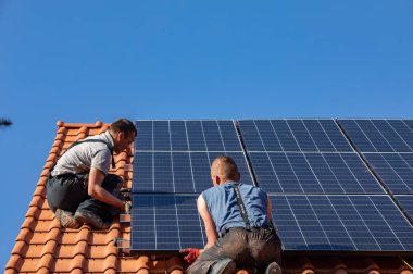 Ochojno, Polonya - 8 Nisan 2020: İşçiler Ochojno 'da bir evin çatısına güneş enerjisi panelleri kuruyorlar. Polonya