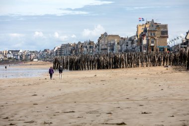 St. Malo, Fransa - 14 Eylül 2018: Saint Malo 'nun pitoresk plajında insanların romantik yürüyüşü. Britanya, Fransa