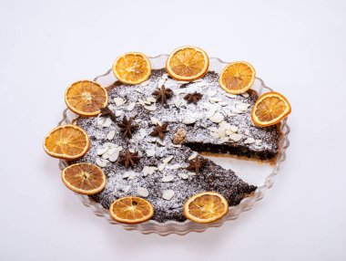 Haşhaş tohumlu tart ve üzerine toz şeker serpiştirilmiş meyve.