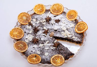 Haşhaş tohumlu tart ve üzerine toz şeker serpiştirilmiş meyve.