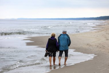 Aktif ve sağlıklı bir yaşam tarzı. Kumlu bir sahil kıyısında yürüyorum
