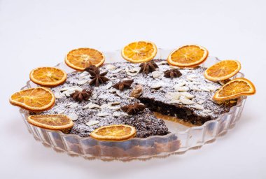 Haşhaş tohumlu tart ve üzerine toz şeker serpiştirilmiş meyve.