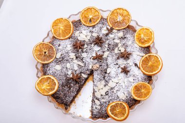 Haşhaş tohumlu tart ve üzerine toz şeker serpiştirilmiş meyve.