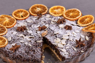 Haşhaş tohumlu tart ve üzerine toz şeker serpiştirilmiş meyve.