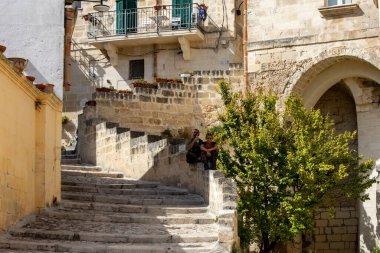 Matera, İtalya - 15 Eylül 2019: Matera şehrinin tarihi bir bölgesi olan Sassi di Matera 'da bir ara sokaktaki tipik kaldırımlı merdivenler. Basilicata. İtalya