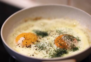 Kızarmış yumurtalı tavaya dereotu serpilmiş. 