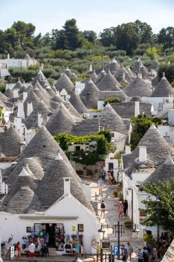 Alberobello, İtalya - 16 Eylül 2019: Trulli köyünde geleneksel beyaz evler. Alberobello, İtalya. Yapım tarzı İtalya 'nın Apulia bölgesindeki Murge bölgesine özgüdür (İtalyan Puglia bölgesinde). Kireç taşı ve temel taştan yapılmış..
