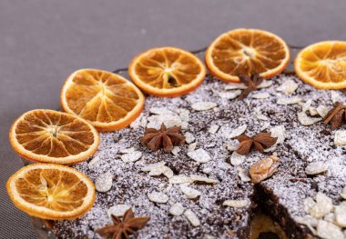 Haşhaş tohumlu tart ve üzerine toz şeker serpiştirilmiş meyve.