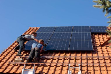 Ochojno, Polonya - 8 Nisan 2020: İşçiler Ochojno 'da bir evin çatısına güneş enerjisi panelleri kuruyorlar. Polonya
