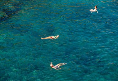 Polignano a Mare, İtalya - 17 Eylül 2019: İnsanlar Polignano a Mare, Adriyatik Denizi, Apulia, Bari ili, İtalya 'daki sevimli Lama Monachile plajında dinleniyor ve yüzüyorlar,